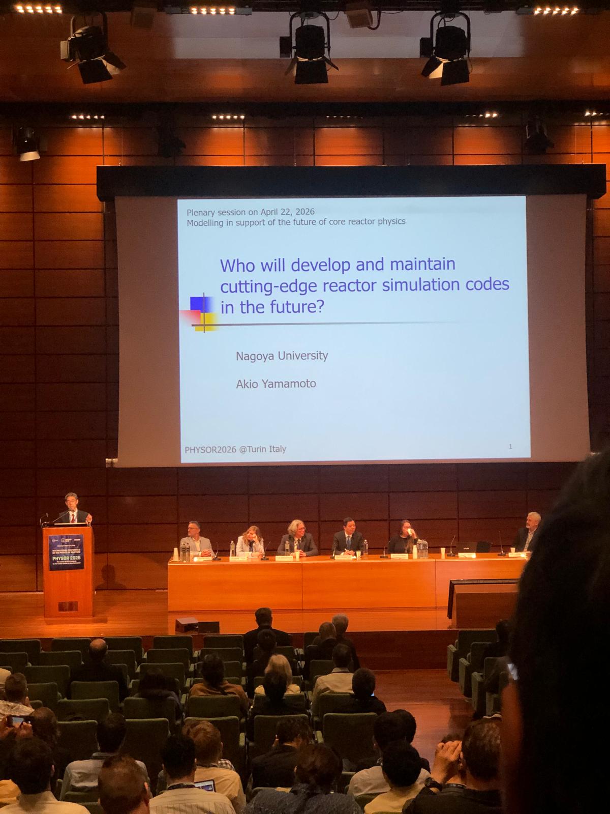 A picture taken at the main assembly hall at the Centro Congressi Lingotto in Turin, Italy with slides written - Dr. Akio Yamamoto from Nagoya University: Who will develop and maintain cutting-edge reactor simulation codes in the future? From April 22, 2026's plenary session at PHYSOR 2026. 